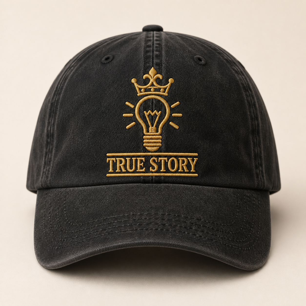 Washed black True Story cap with enlarged gold crown and lightbulb embroidery
